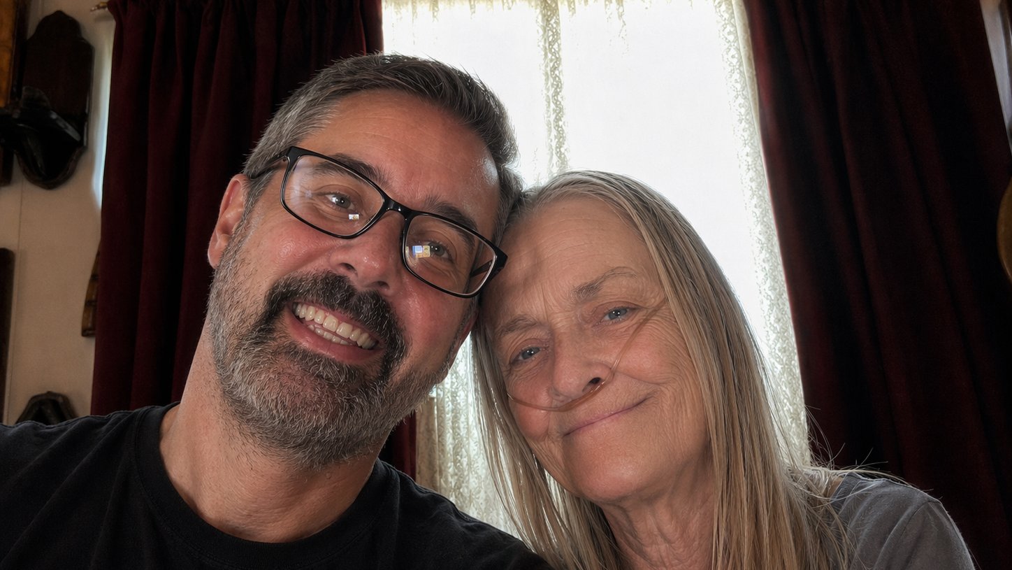 A volunteer smiling with an elderly woman during a home visit
